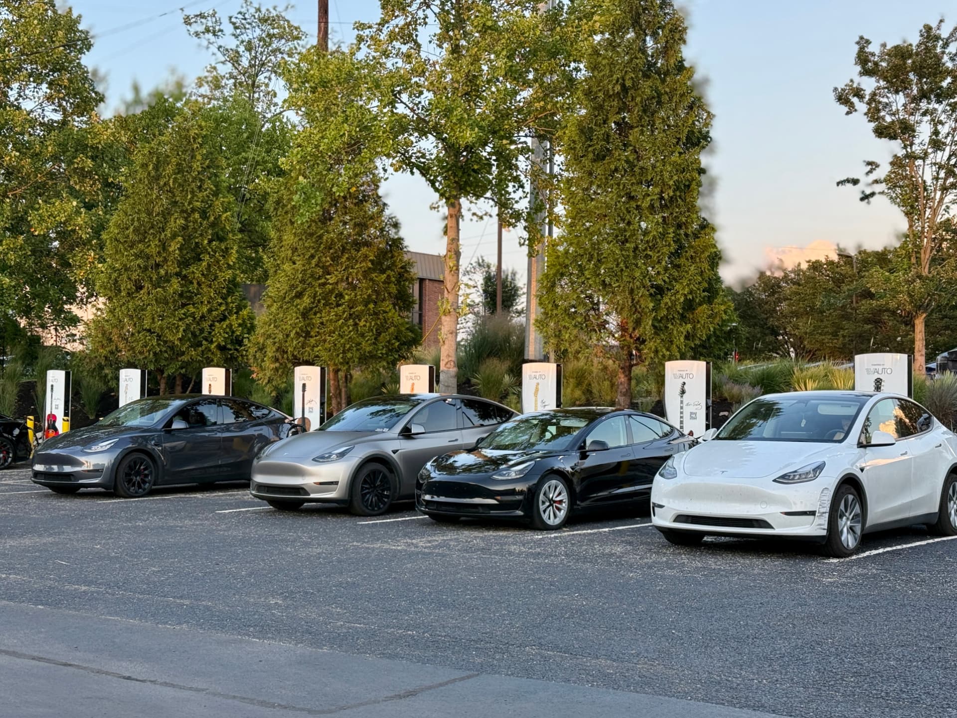 Custom wrapped Tesla Superchargers at a commercial charging site