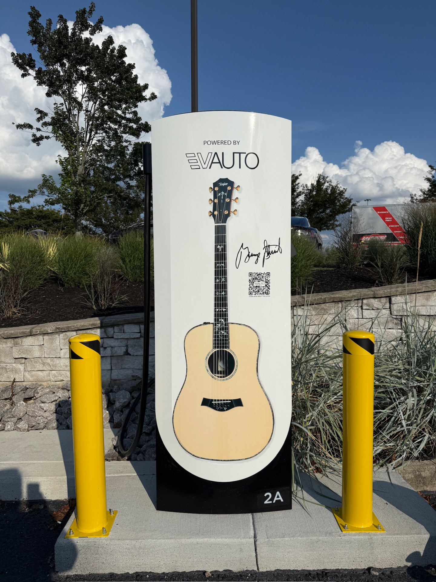 Finished Tesla Supercharger wrapped with a Powered by EVAUTO acoustic guitar graphic in Brentwood, Tennessee